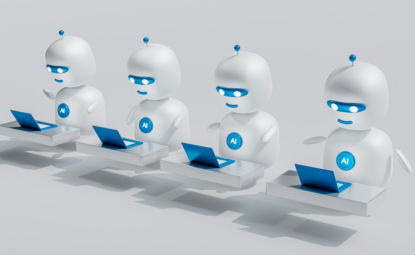 A group of white robots sitting on laptops